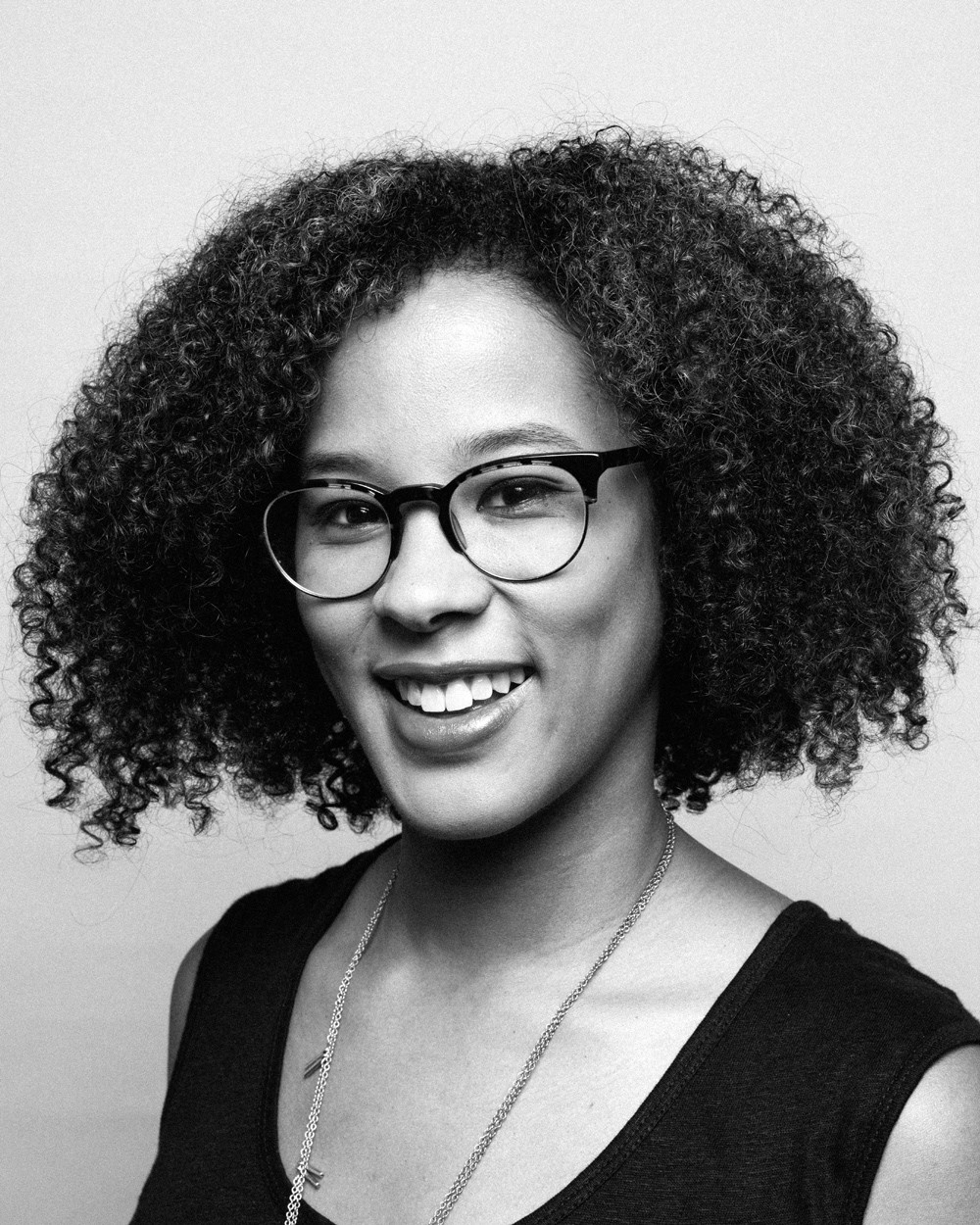 headshot of Megan Ming Francis, african american woman wearing glasses, with big simle