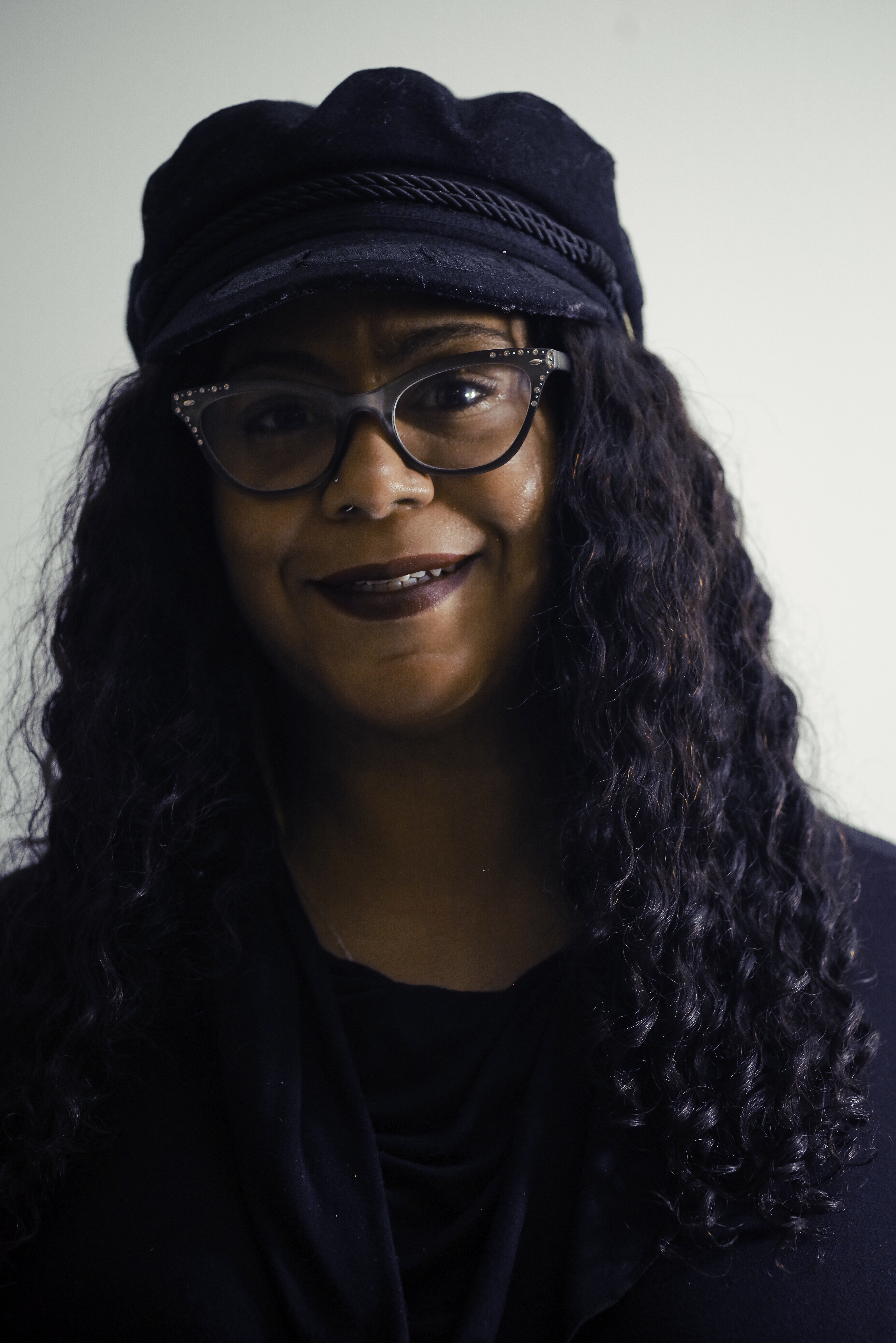 headshot of Shay Bouley, african american woman smiling with glasses and black hat